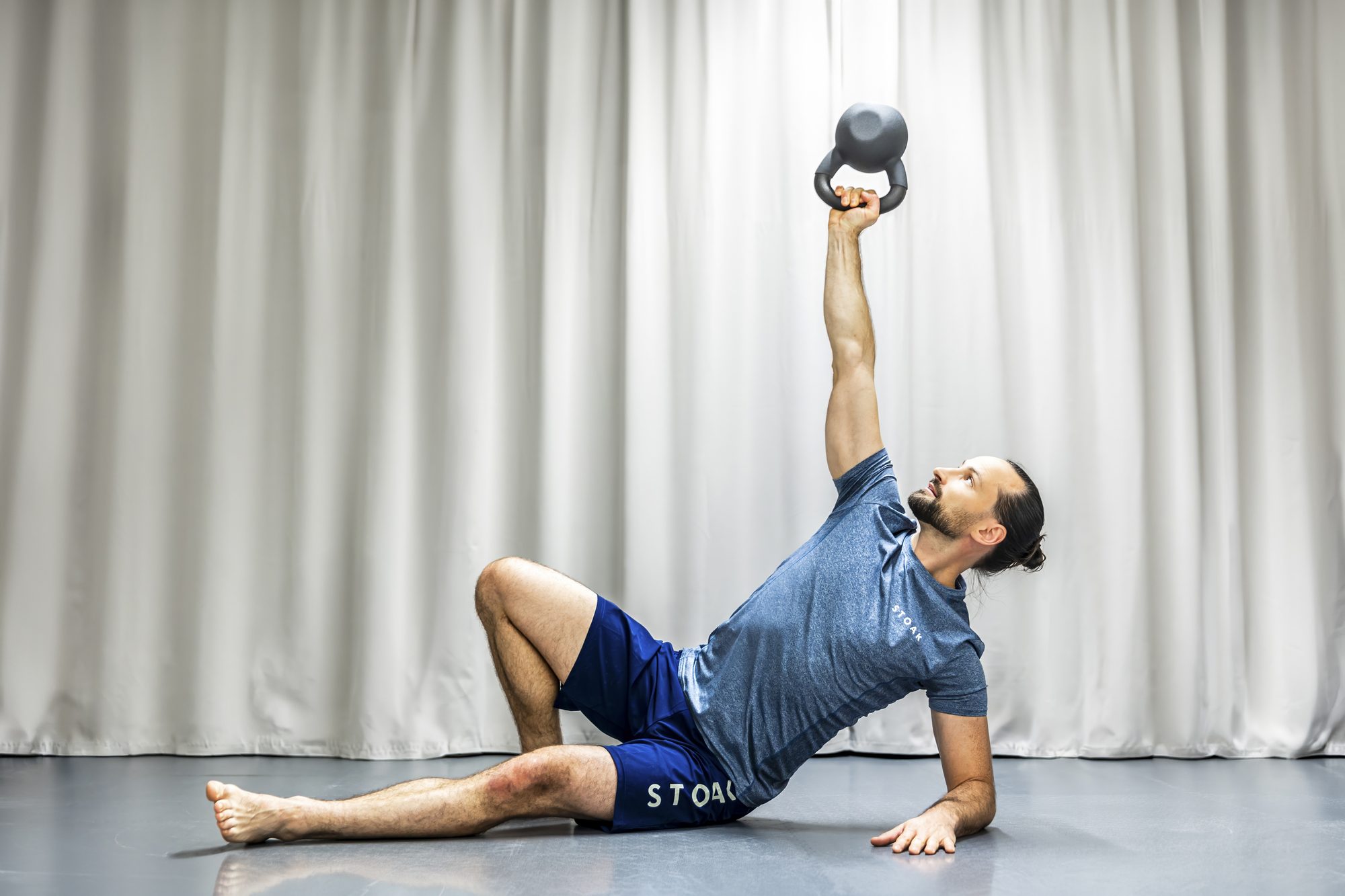 Bernhard Woisetschläger im Seitstütz mit gestreckter Kettlebell über dem Kopf